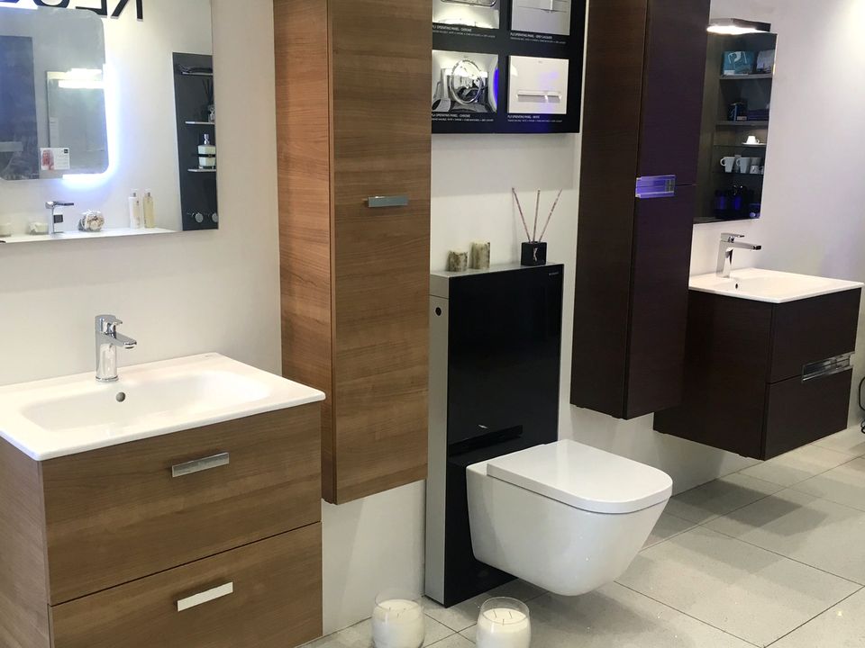 Walnut vanity unit, backlit mirror and wall-hung WC in the Elite Bathrooms showroom, Wood Green