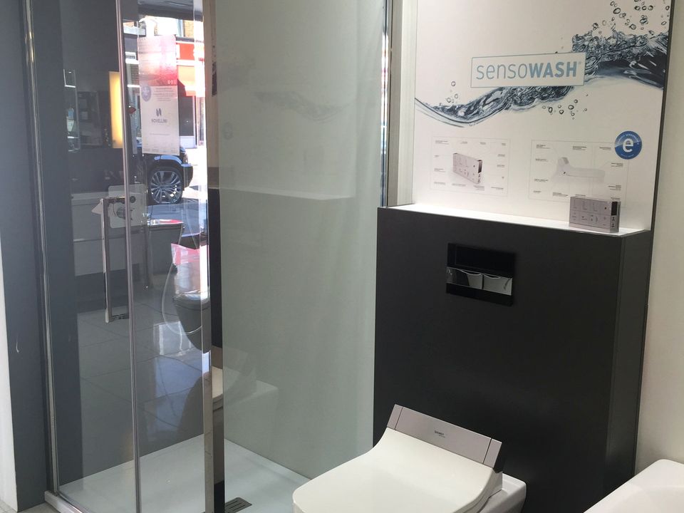 Freestanding basin unit with a lit mirror and shower enclosure