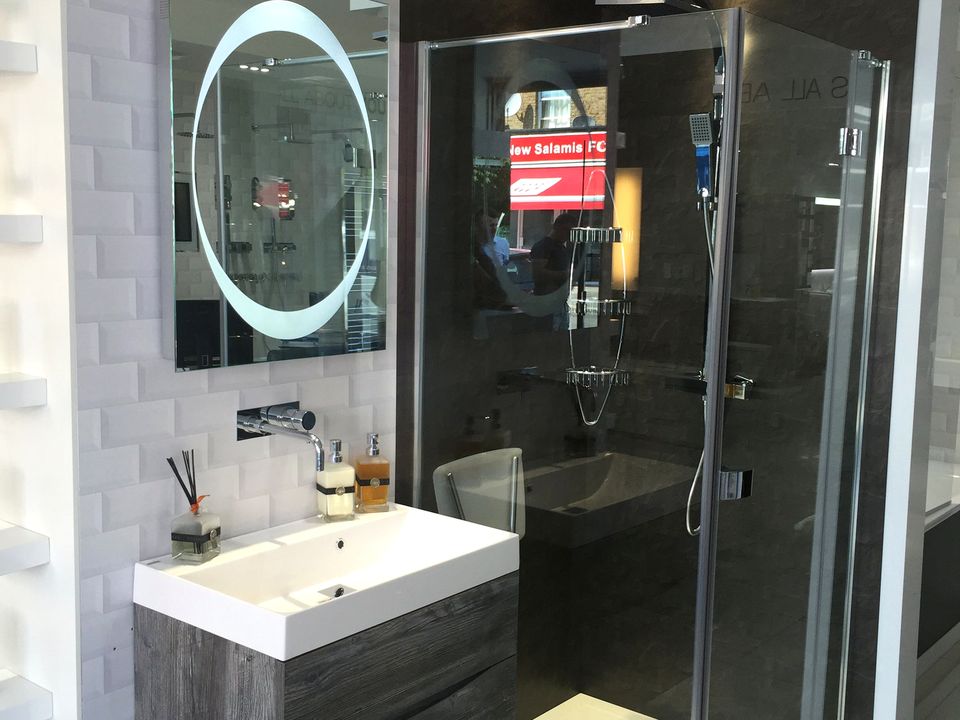 Compact bathroom set with a white basin unit and patterned black shower panel
