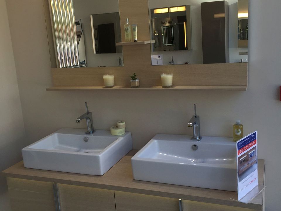 Bathroom mirror cabinet with integrated lighting and a close-coupled WC beside it